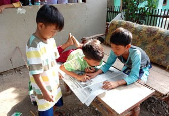 Anak anak warga Kalinusu Brebes sedang membaca koran dari Satgas TMMD.Kamis, (15/10/2020)  