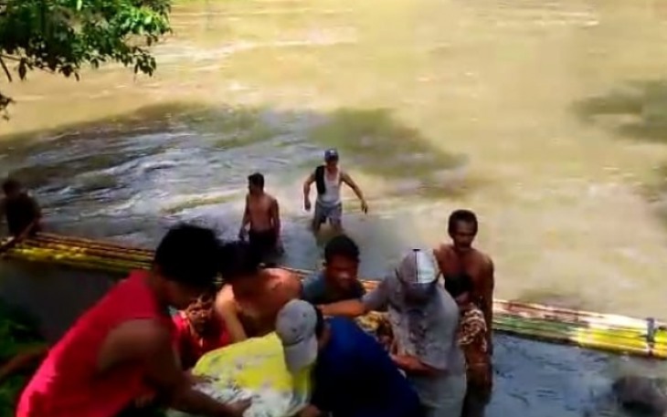 Tim pencarian bersama masyarakat setempat saat mengevakuasi jenazah korban yang terseret arus sungai Jum'at lalu pada Minggu (9/12/18)