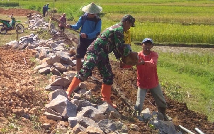 Serda Toharis Babinsa aktif Koramil 13 Salem Kabupaten Brebes saat membantu pelaksanaan pembangunan Talud