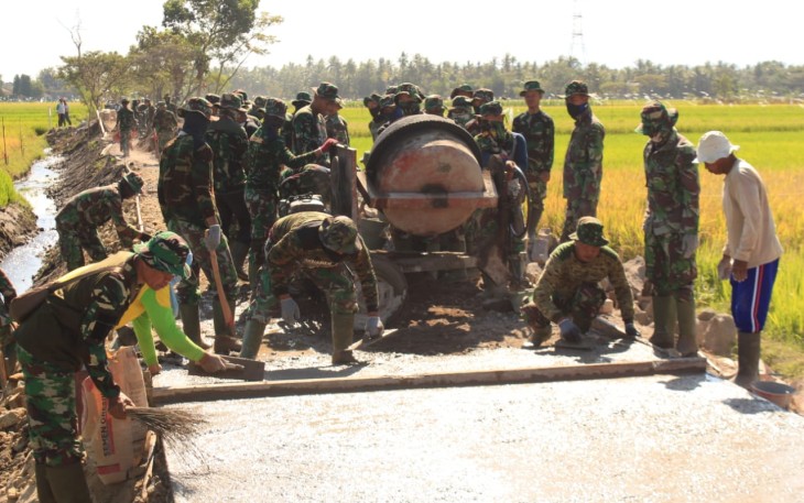 Personil TNI Sedang Melakukan Pekerjaan Betonisasi Jalan 