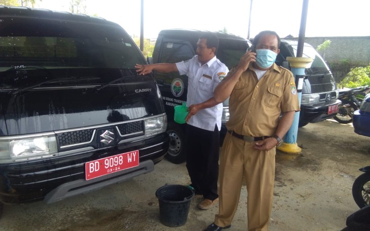 Tampak pegawai Dishub (kiri) saat membersihkan mobil yang belum disalurkan