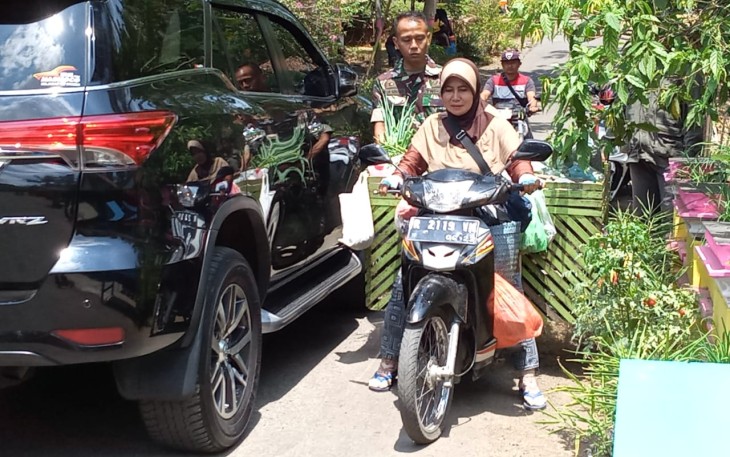 Satgas TMMD Bantu Penjuall Sayur Lintasi Jalan Sempit di Lokasi TMMD 106 Kodim Cilacap