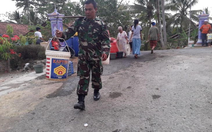 Kepedulian dan Kemanunggalan Ditunjukkan Sertu Budi Dengan Memikul Air Bersih