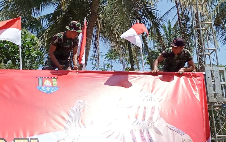 Pemasangan Banner Upacara Penutupan TMMD