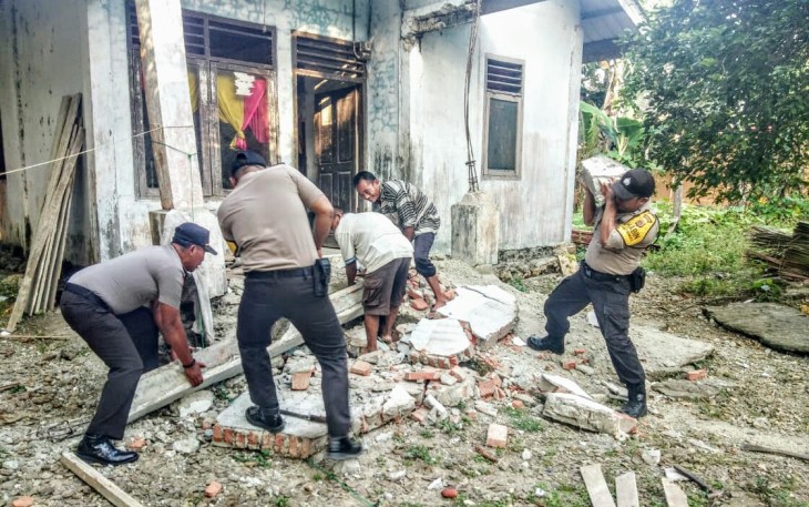 Personel Polres Simeulue saat membersihkan puing-puing bangunan yang roboh dan hancur