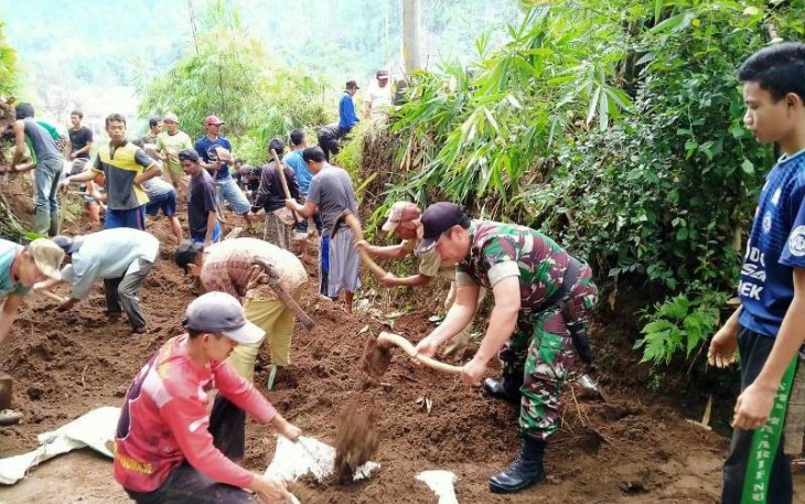 warga desa dibantu aparat TNI bersihkan material longsor