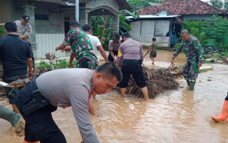Anggota Koramil Wedarijaksa dan Shabara Polres Pati membersihkan sisa-sisa sampah banjir