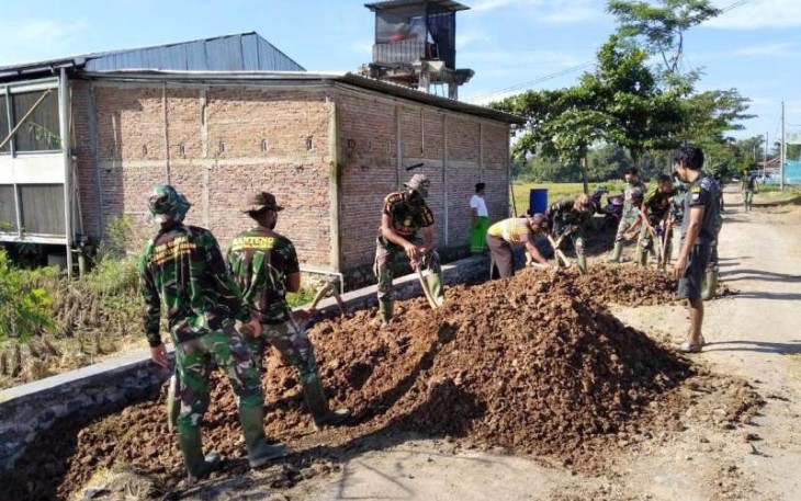 Anggota Satgas Rapikan Sisa Pekerjaan Talud