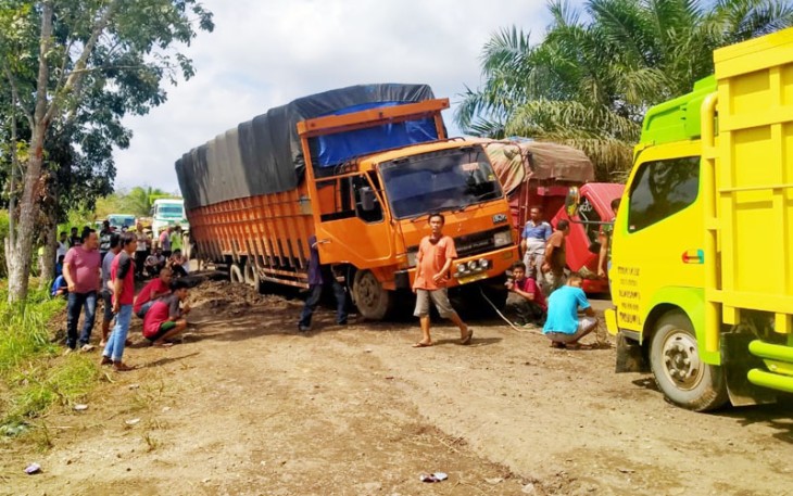 Tampak truk angkutan terjebak dijalan rusak