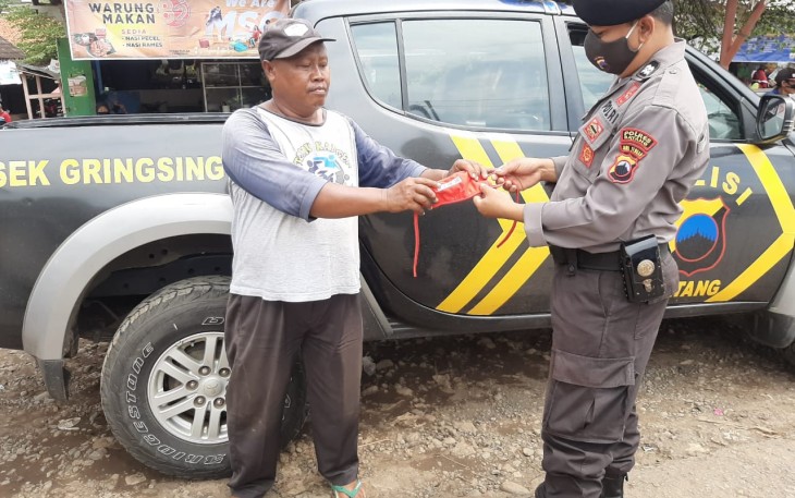 Anggota Polsek Gringsing memberikan masker kepada pelanggar Operasi Yustisi di depan Pasar Plelen, Gringsing. Sabtu(7/11/2020).