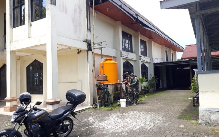 Personil satgas TMMD saat bantu warga cat rumah ibadah