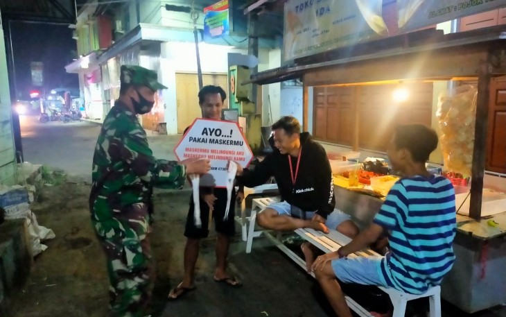 Batuud Peltu Arifin bersama rekan Babinsa menghimbau masyarakat tetap mematuhi protokol kesehatan dan membagikan masker disekitaran komplek Pasar Tersono, Kecamatan Tersono, Kabupaten Batang, Minggu (13/6/12) malam. 