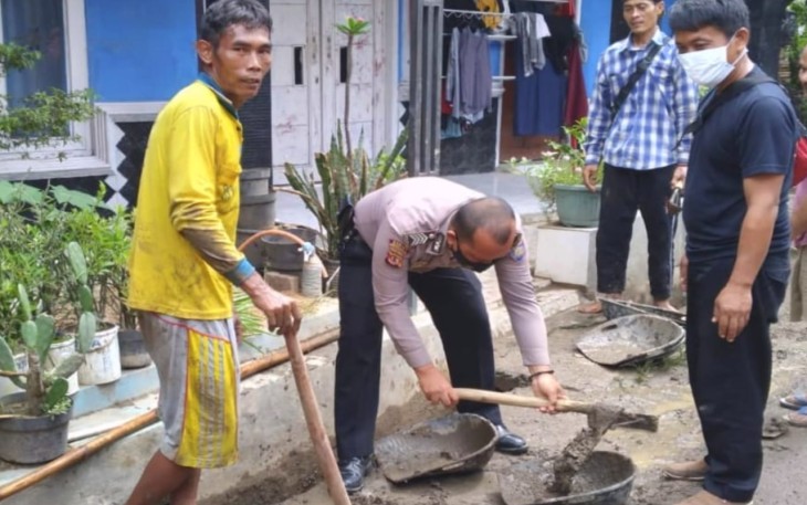 Bripka Adhi Firmansyah bergotong royong bersama warga membersihkan parit di wilayah Kasokandel 