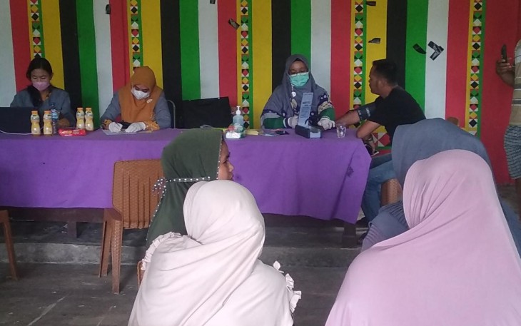 Tenaga Kesehatan Puskesmas Singkil, saat memeriksa warga dalam kegiatan vaksinasi covid-19 di Desa Pea Bumbung