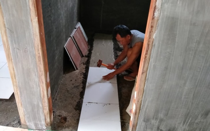 Personil satgas TMMD Kodim 1310/Bitung saat mengerjakan pemasangan tehel