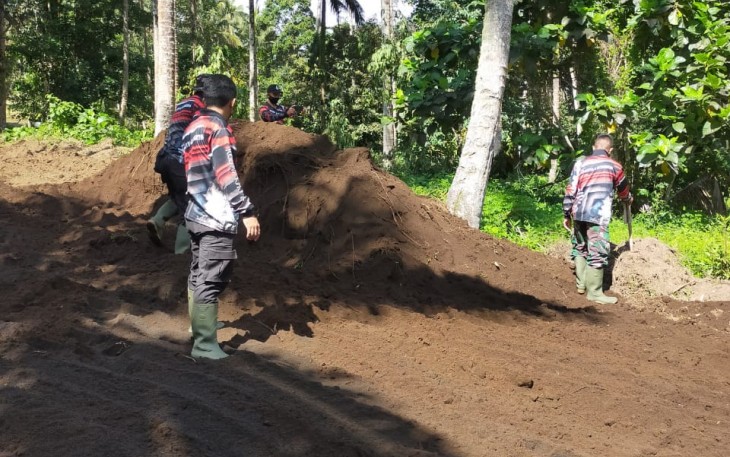 Personil satgas melakukan pembersihan samping bahu jalan