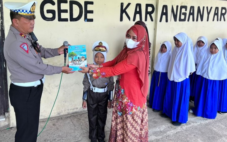  Penyerahan secara simbolis buku Pendidikan Lalu Lintas Kanit oleh Kamsel Polres Karanganyar, Ipda Teguh Sarwono kepada salah satu guru di SD Negeri 2 Tegalgede, Kabupaten Karanganyar, Kamis (25/8/2022). (Foto : Istimewa)