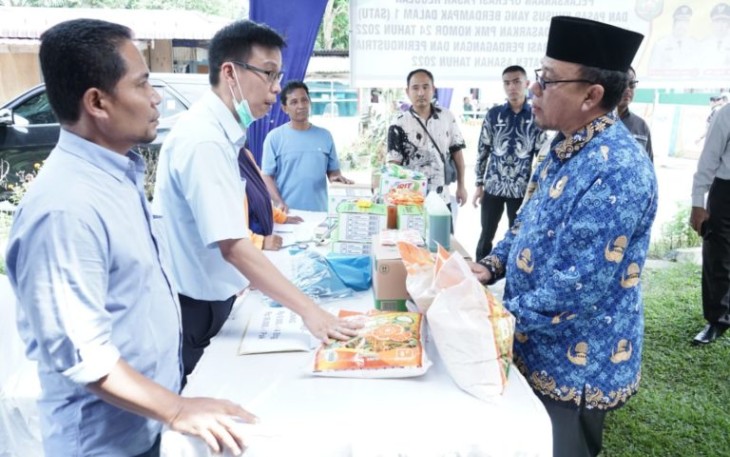 Kepala Dinas Koperasi Perdagangan dan Perindustrian Kabupaten Asahan Drs. Ilham, MM saat menyampaikan laporan kegiatan dihadapan Sekretaris Daerah Kabupaten Asahan, Asisten Perekonomian dan Pembangunan, Kepala Desa Sipaku Area serta tamu undangan lainnya di Halaman Balai Desa Sipaku Area Kecamatan Simpang Empat, Kamis (03/11/2022).