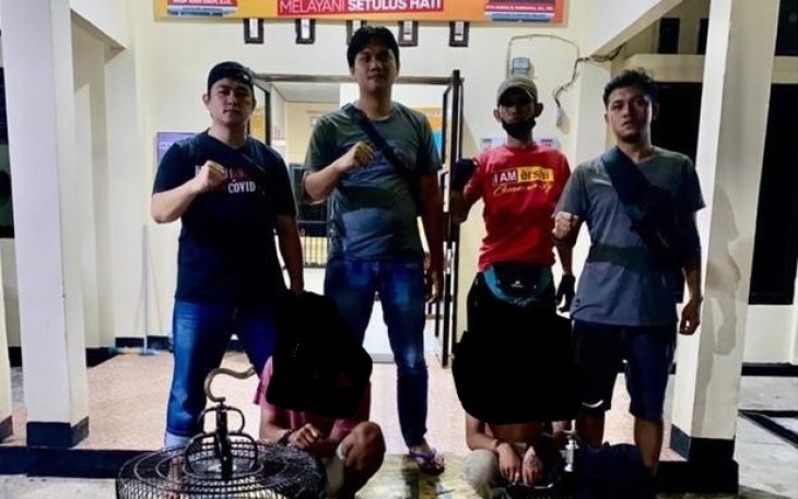 Dua orang pelaku (jongkok) saat diamankan petugas