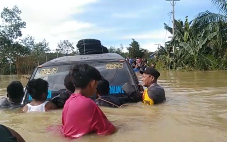 Bhabinkamtibmas Polsek Ranto Peureulak saat Berjibaku Membantu Evakuasi Mobil Terseret Banjir