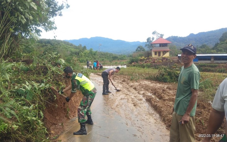 Tim Patroli Polsek gotong royong bersama Anggota Babinsa dan Warga berupaya membersihkan material tanah longsor 