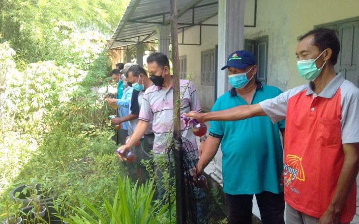 Pemerintah Desa Tanjung bersama warga saat penyemprotan Eco Enzyme pada tanaman milik tim PKK