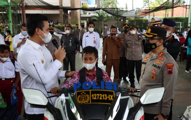 Usai divaksin, anak-anak berfoto di atas kendaraan dinas Polisi