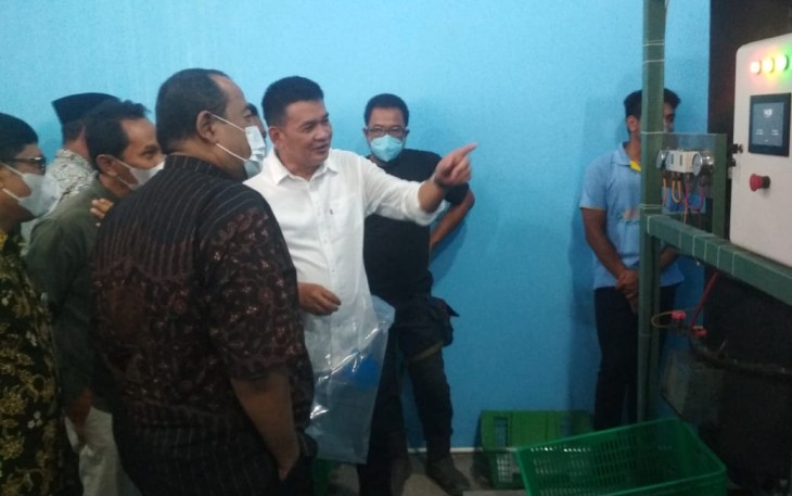 Dirut PUDAM Tirta Lawu, Prihanto (berkemeja putih), saat menerangkan cara kerja mesin produksi es kristal.