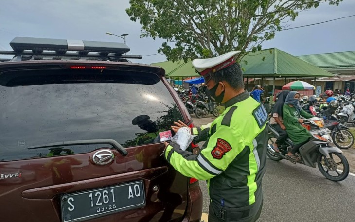 Petugas pasang stiker Kamseltibcarlantas dan Prokes