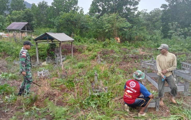 Pembersihkan makam bersama warga  di perbatasan