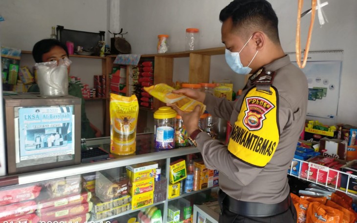 Bhabinkamtibmas saat cek migor di salah satu warung milik warga