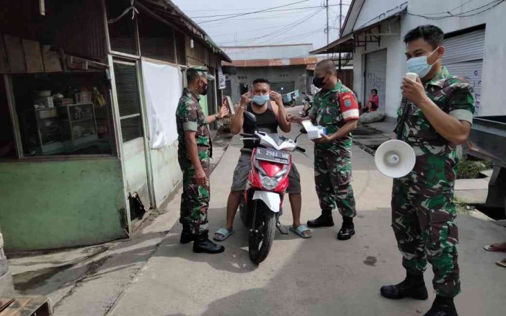 Babinsa Koramil 1015 - 08/Mentawa Baru Ketapang Operasi Yustisi Bagikan Masker