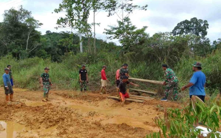 Satgas Yonif 144/JY Benahi Jalan Berlobang Bersama Warga