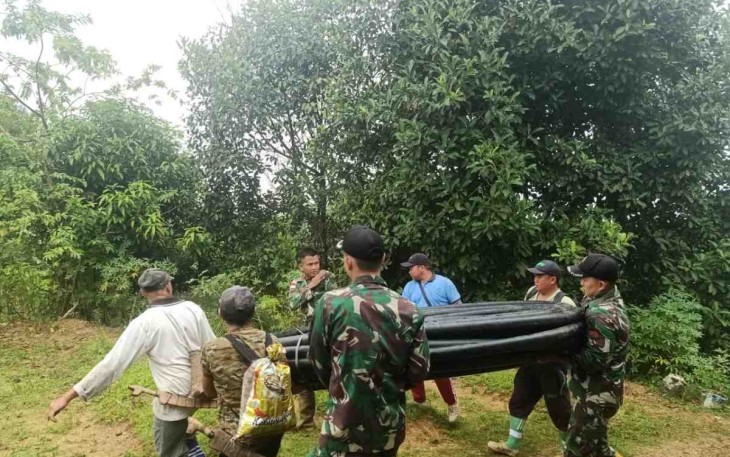 Anggota Satgas Yonif 144/JY Bantu Pemasangan Pipa Air Bersih Bersama Warga