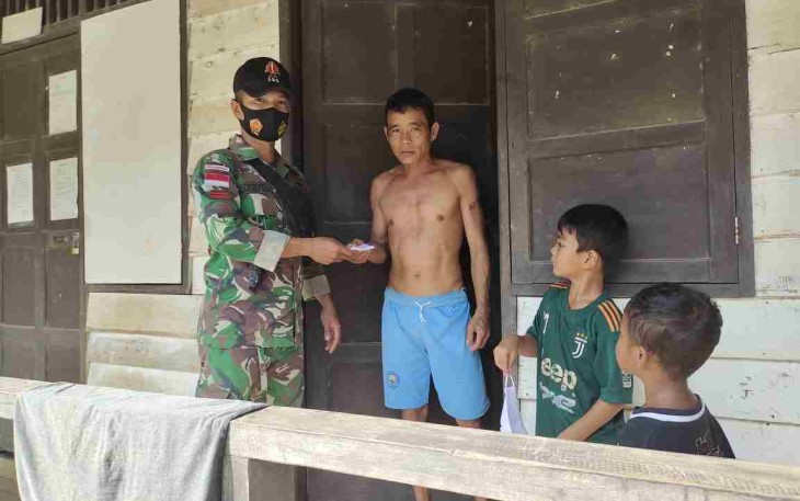 Anggota Satgas Yonif 144/JY Bagikan Masker ke Rumah Warga 