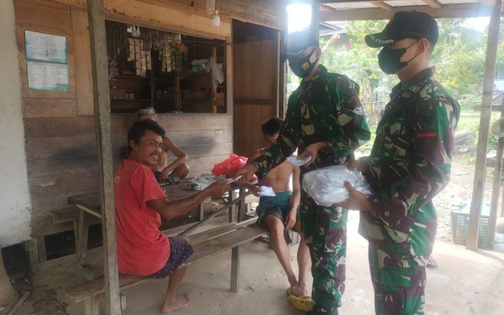 Anggota Satgas Yonif 144/JY Bagikan Masker Ke Rumah Warga di Perbatasan