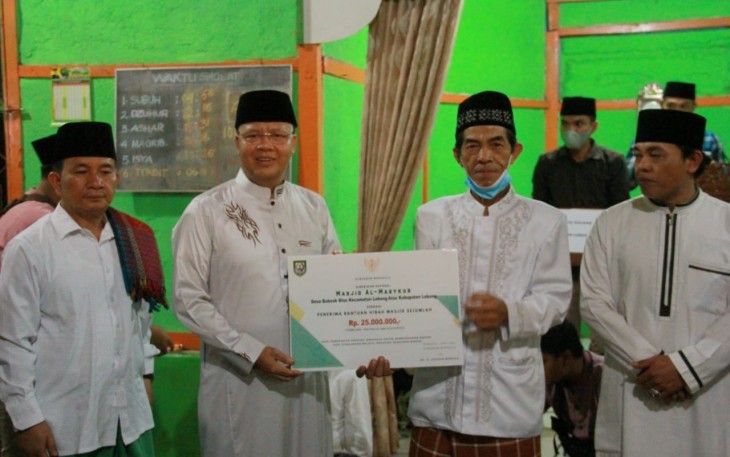 Gubernur Rohidin, saat menyerahkan bantuan