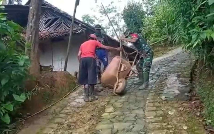 Serma Zainal gotong royong pengecoran jalan di desa Jetis Lor. Rabu (20/4/22)