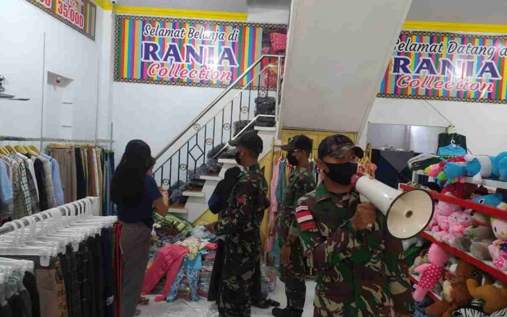 Gunakan toa, satgas yonif mekanis 643/Wns himbau prokes di pusat keramaian. Selasa (26/4/2022)