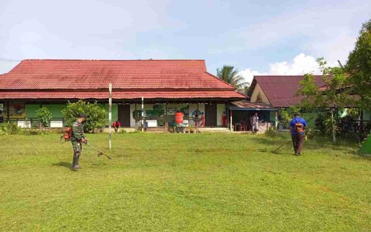 Satgas Yonif Mekanis 643/Wns pangkas rumput di lingkungan sekolah. Jum'at (29/4/2022)