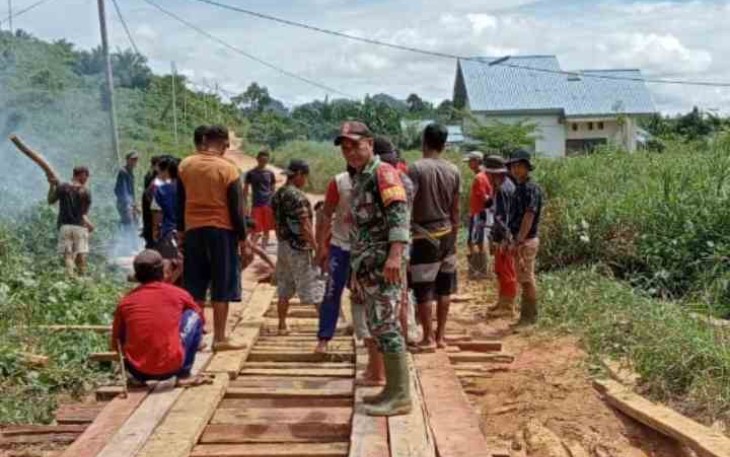 Berjibaku bersama warga benahi jalan desa menggunakan papan kayu. Minggu (15/05/2022)