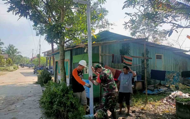 Gotong royong pasang tiang listrik bersama warga
