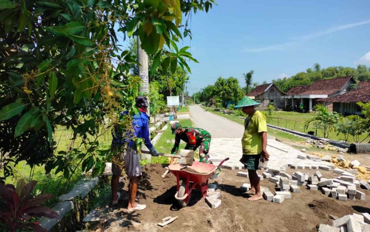 Bantu warga pasang paving jalan di desa binaan