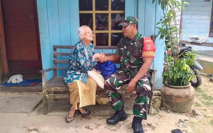 Serma Sayik saat memberikan bantuan ke warga kurang mampu di wilayah binaan
