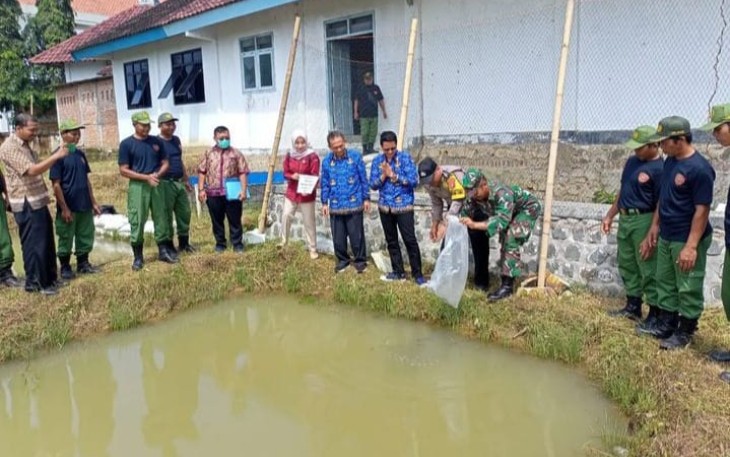 Sertu Sunaryo  saat tebar benih ikan di wilayah desa binaan