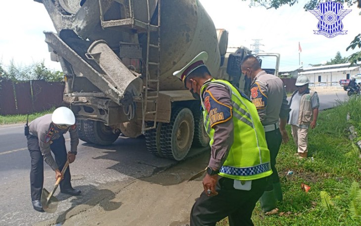 Anggota Satlantas saat turun langsung mencangkul dan meratakan batu pecah bercampur semen pada bagian jalan yang rusak dan berlubang.