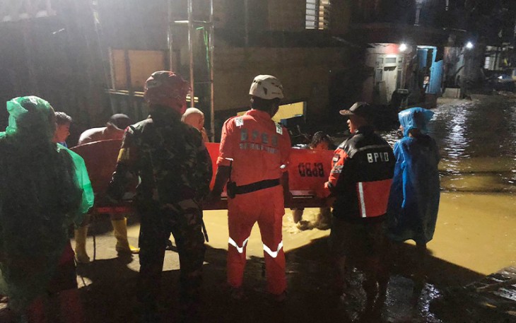 Petugas dan warga bergotong royong angkat perahu karet 