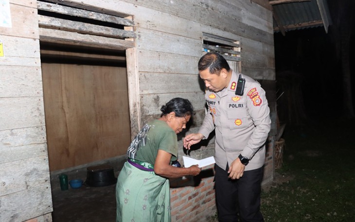 Kapolres Aceh Timur, Polda Aceh AKBP Mahmun Hari Sandy Sinurat, S.I.K. saat membagikan sembako ke salah seorang warga, Kamis (09/06/2022) malam.