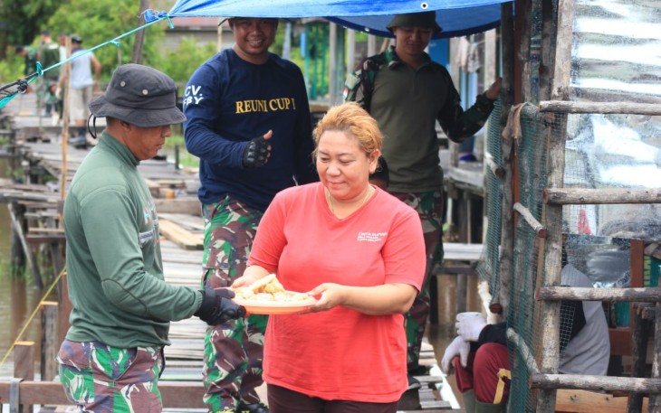 Yeni Septiana (34) saat menunjukan rasa terima kasihnya kepada TNI dengan memberikan makanan ringan berupa kue kepada personel TMMD ke 115