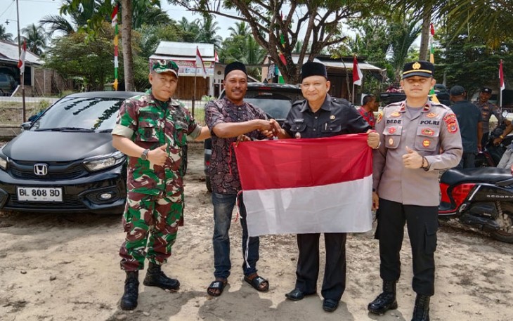Kapolsek Peureulak Barat Bersama Muspika Bagikan Bendera Merah Putih ke Masyarakat